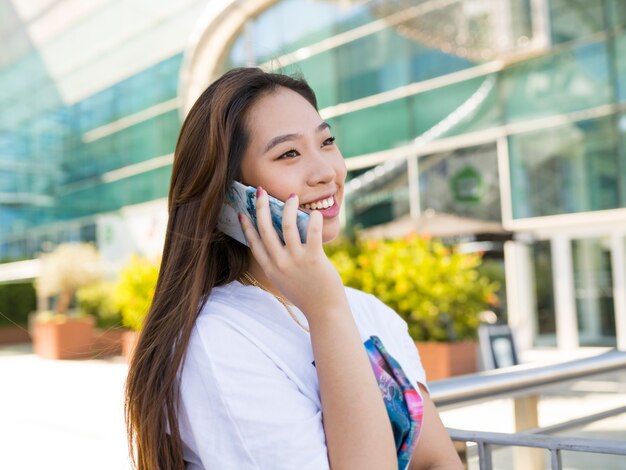 市内で電話で話しているアジアの女性