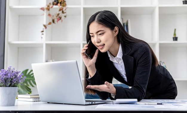 전화 통화를 하는 아시아 여성, 그녀는 신생 기업의 영업 사원이며 제품과 판촉물을 판매하기 위해 고객에게 전화를 걸고 있습니다. 전화 채널을 통해 제품을 판매하는 개념.