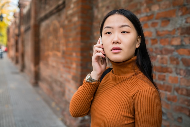 アジアの女性が電話で話しています。