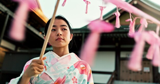 Foto donna asiatica al tempio e ombrello viso con tradizione e religione giovane turista o locale a tokyo abbigliamento tradizionale cultura e benessere giapponese con viaggio e ombrellone per il sole all'aperto