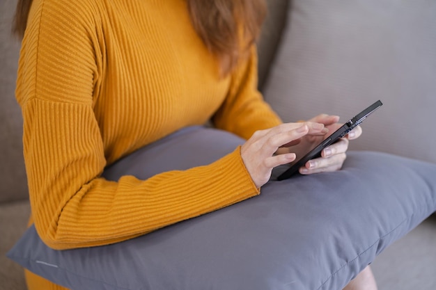 Asian woman texting checking social media holding smartphone at home Conversation with boyfriend or friend