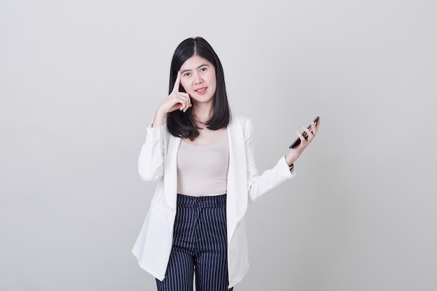 Asian woman thinking holding mobile phone