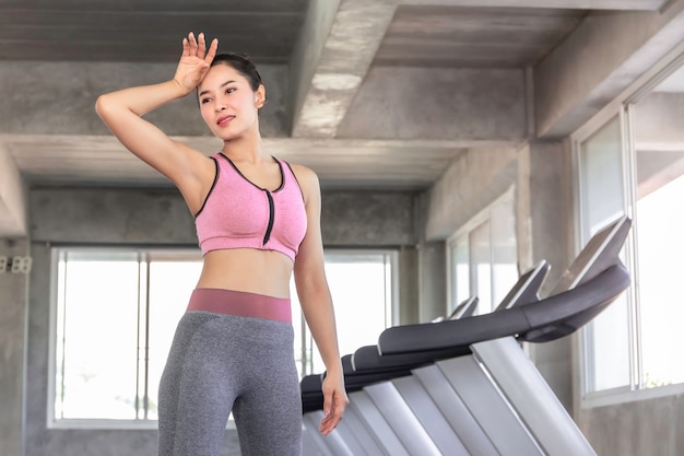 Donna asiatica stanca dopo l'allenamento di allenamento in palestra.