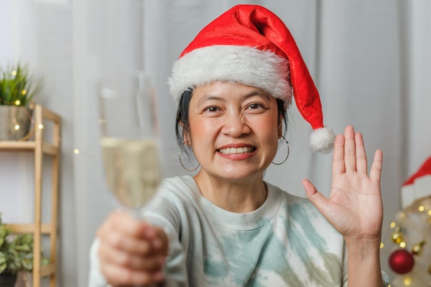 Asian woman toasting champagne celebrate new year and Christmas party video call friends at home