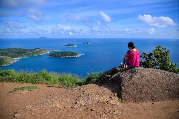 Asian woman on a top of mountain view point relaxing on beautiful sea view