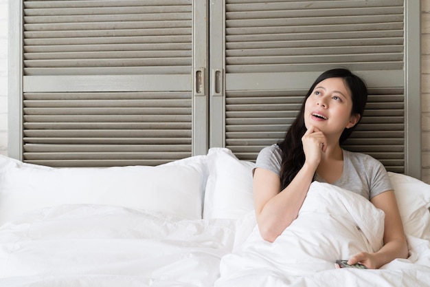 Asian woman touching her chin and come up with a new idea while
she is watching the tv series. she suddenly figure out some
philosophy of life.