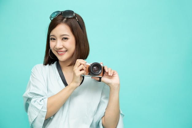 Asian woman tourist holding digital camera isolated
