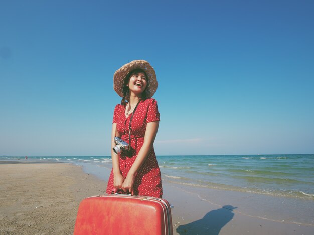 アジアの女性はタイのビーチの青い空を旅します。