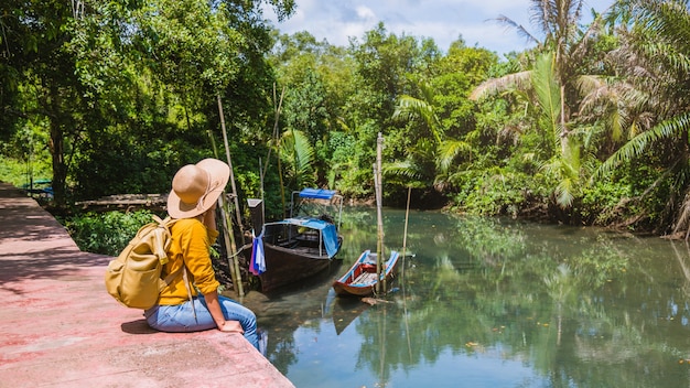 アジアの女性は自然を旅行します。旅行リラックス。ボートの写真。 thapom-klong-song-namで美しい自然を見ながら座っています。タイのクラビ。