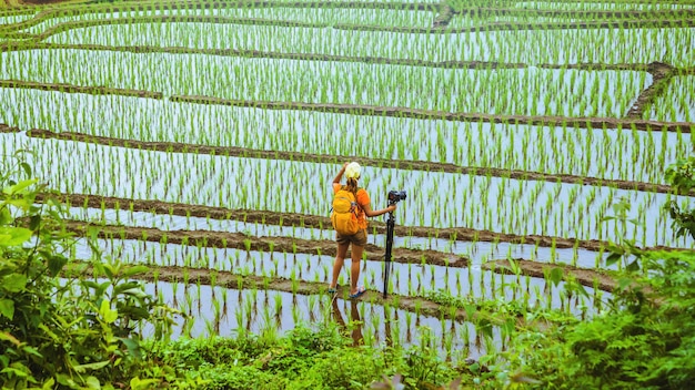 Photo asian woman travel nature. travel relax. walking take a photo on the field. in summer.