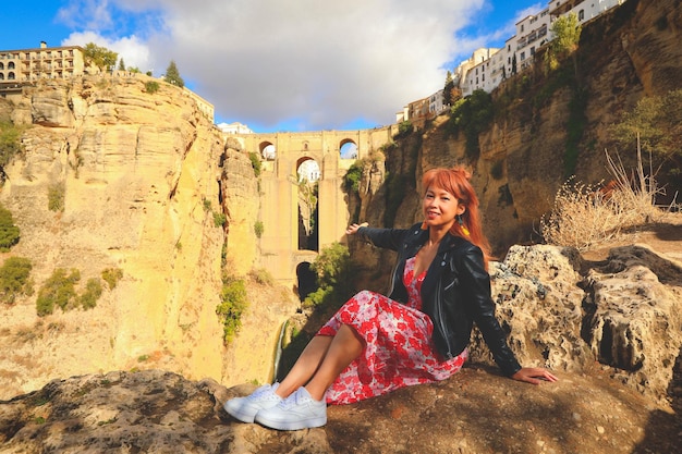 Foto donna asiatica in viaggio a ronda, in spagna, con vista sul nuovo ponte puente nuevo sul retro