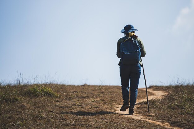 Foto una donna asiatica con uno zaino da viaggio e un cappello di jeans che va in escursione