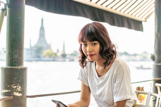 Asian woman traveler taking a photo in cafe