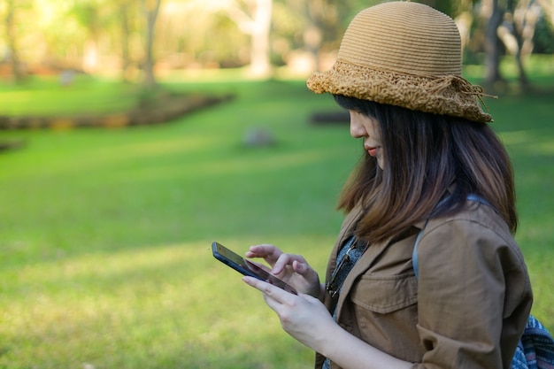 写真 考古学的にスマートな携帯電話を使っているアジアの女性旅行者