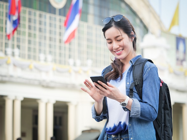 アジアの女性が携帯電話で旅行