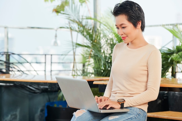 Asian woman typing on laptop