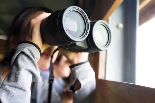 Asian Woman use of the binoculars for birdwatching