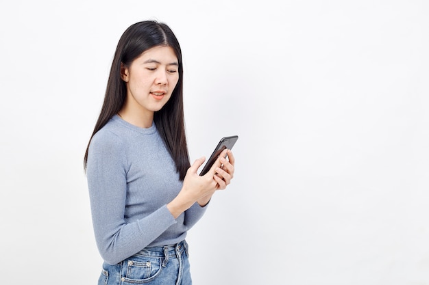 Азиатская женщина пользуется мобильным телефоном