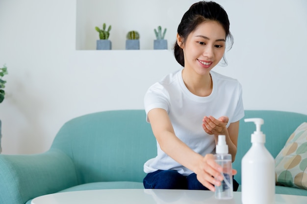 Asian woman using alcohol gel hand sanitizer