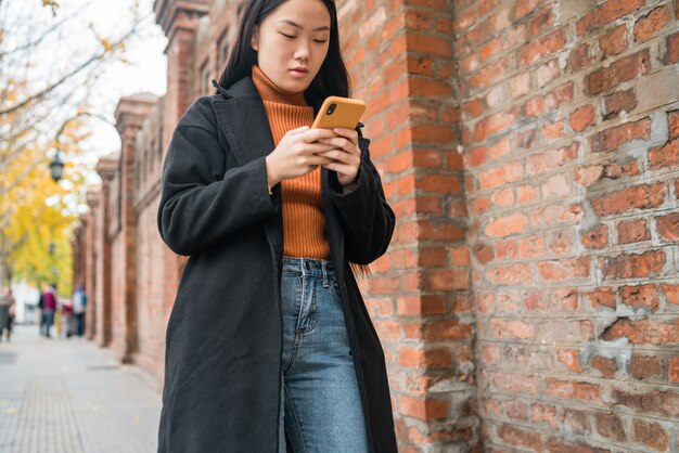 Asian woman using her mobile phone.