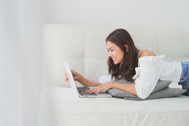 Asian woman using laptop computer in living room