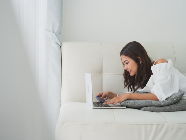 Asian woman using laptop computer in living room