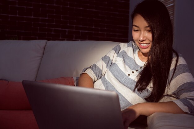 Asian woman using laptop at night