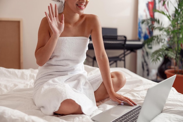 Asian woman using laptop for online communication at home