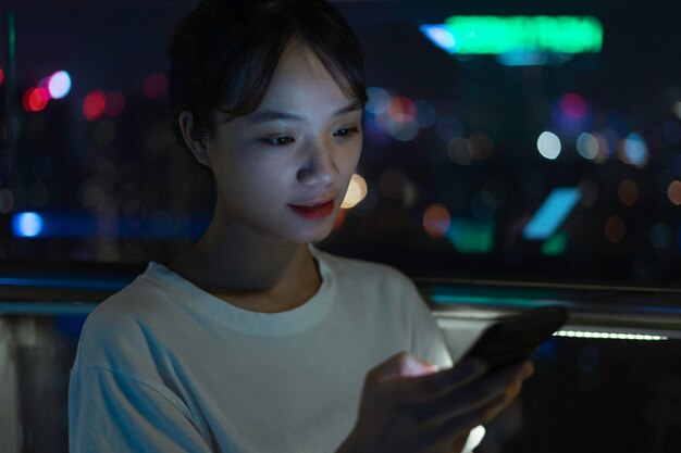 夜に携帯電話を使用してアジアの女性