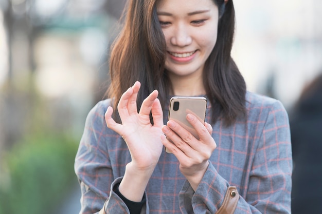 Asian woman using smartphone and taking photos and using applications