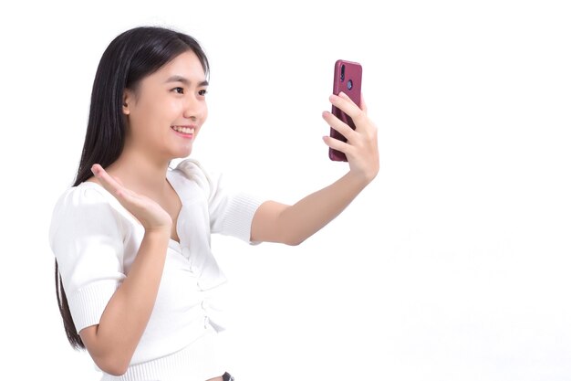 Asian woman using a smartphone for video calling to Talk happily with a friend on a white background