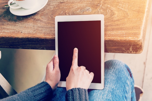 Asian woman using tablet computer in coffee shop with Vintage tone.