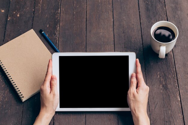 Asian woman using tablet on table in coffee shop with vintage toned.