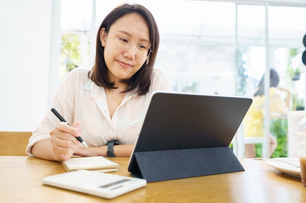 Asian woman using tablet, watching lesson online course communicate