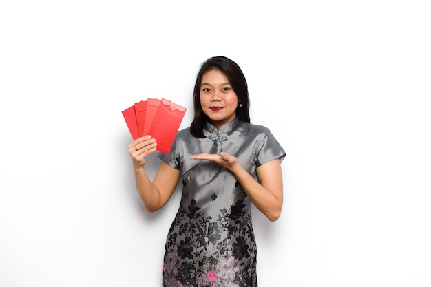 Photo asian woman using traditional cheongsam showing and hold red envelope angpau give it to you