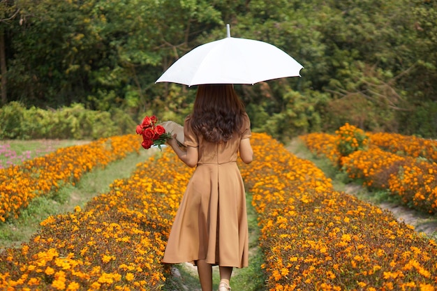 Asian woman walking in a beautiful flower garden