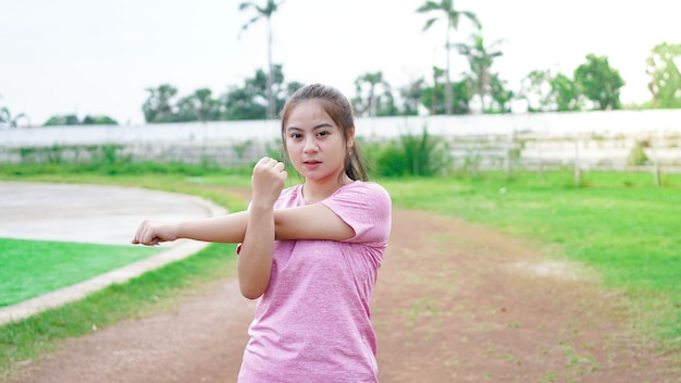 Asian woman warming up before running