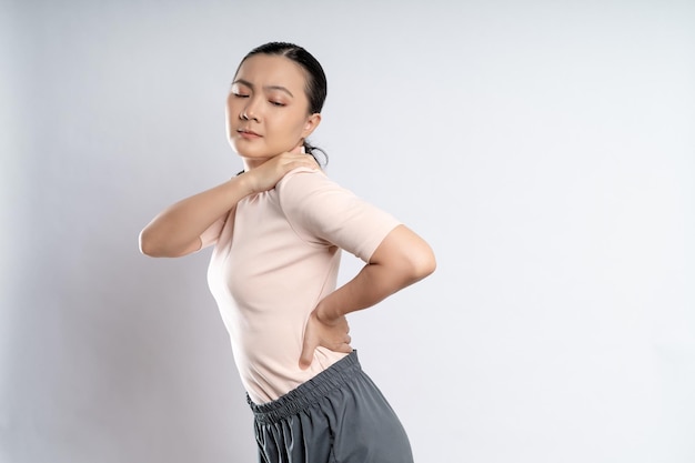 アジアの女性は、白い背景で隔離に立って体の痛みに病気だった