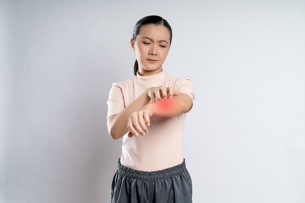 사진 아시아 여성은 배경에 격리된 붉은 반점으로 피부를 가렵게 하는 데 아팠다