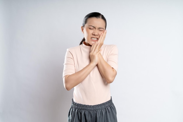 Asian woman was sick with toothache standing isolated on white background