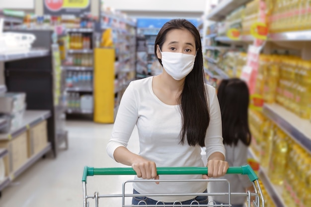 Asian woman wear face mask push shopping cart