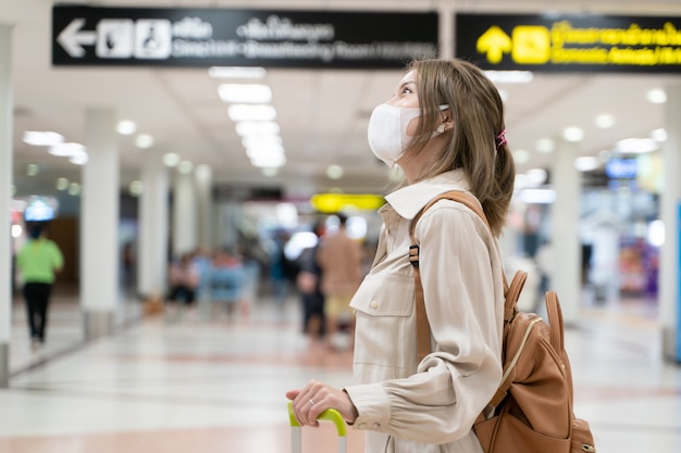 아시아 여성은 공항 터미널에서 여행하는 동안 마스크를 착용 New Normal Covid