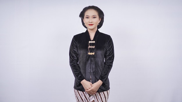La donna asiatica che indossa il kebaya nero sembra elegante isolata su sfondo bianco