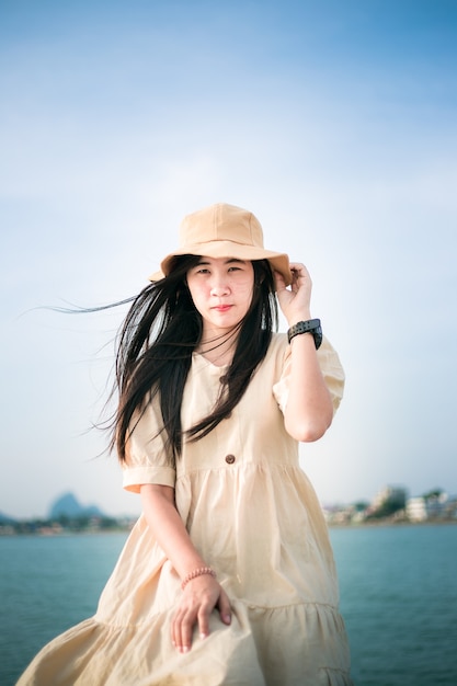 Donna asiatica che indossa un cappello marroneuna bella donna asiatica sorridente con i capelli scuri mostra