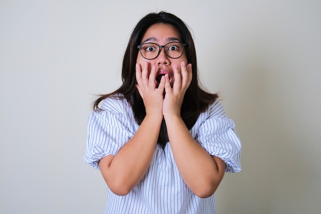 Asian woman wearing eye glasses showing shocked face expression