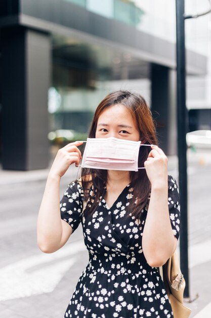 Foto donna asiatica che indossa una maschera facciale per proteggersi dal virus dell'influenza