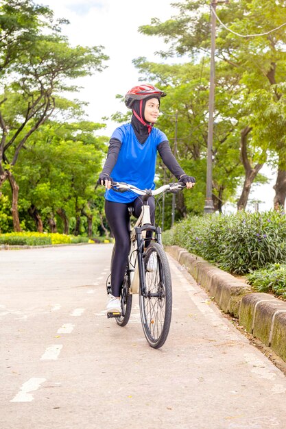 ヘルメットをかぶったアジア人女性が自転車に乗る