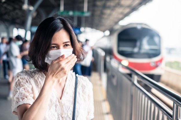 アジアに広がるコロナウイルスを防ぐためのマスクを身に着けているアジアの女性。