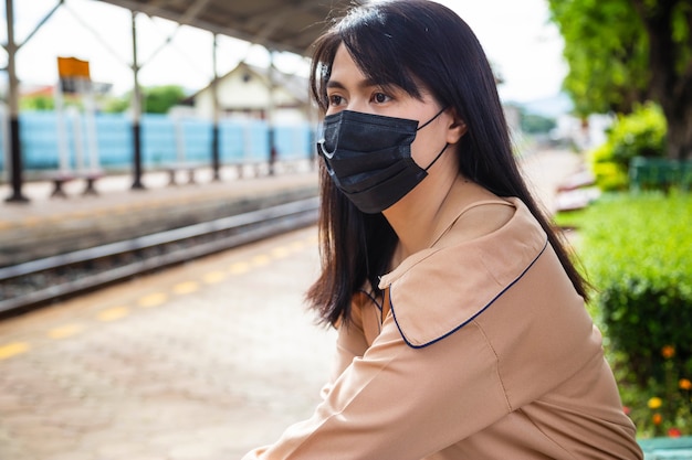 Азиатская женщина в маске для предотвращения заражения COVID-19 или COVID-19