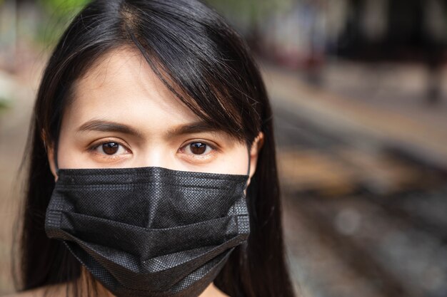 Donna asiatica che indossa una maschera per prevenire covid-19